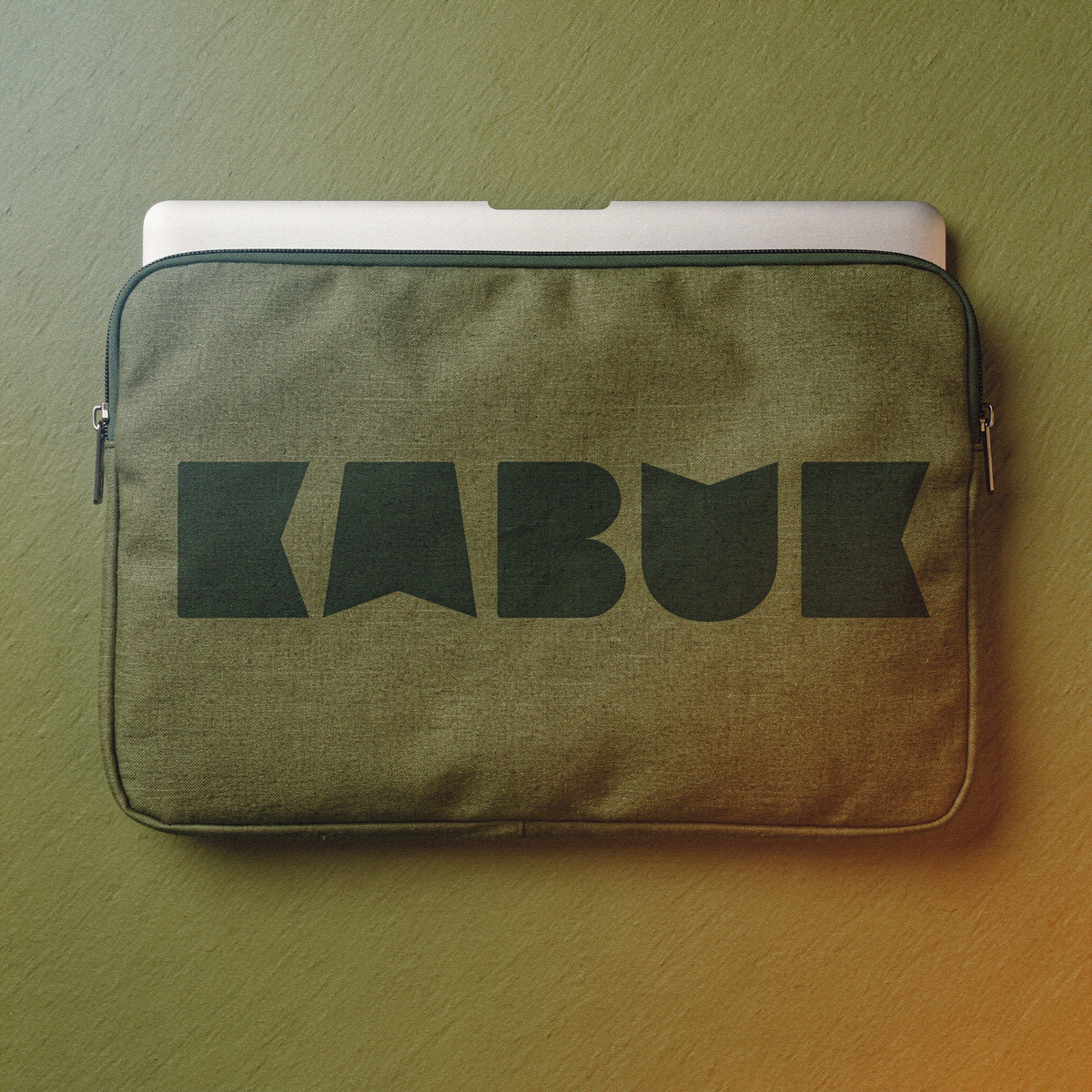Üzerinde büyük logo bulunan haki kumaş laptop kılıfı